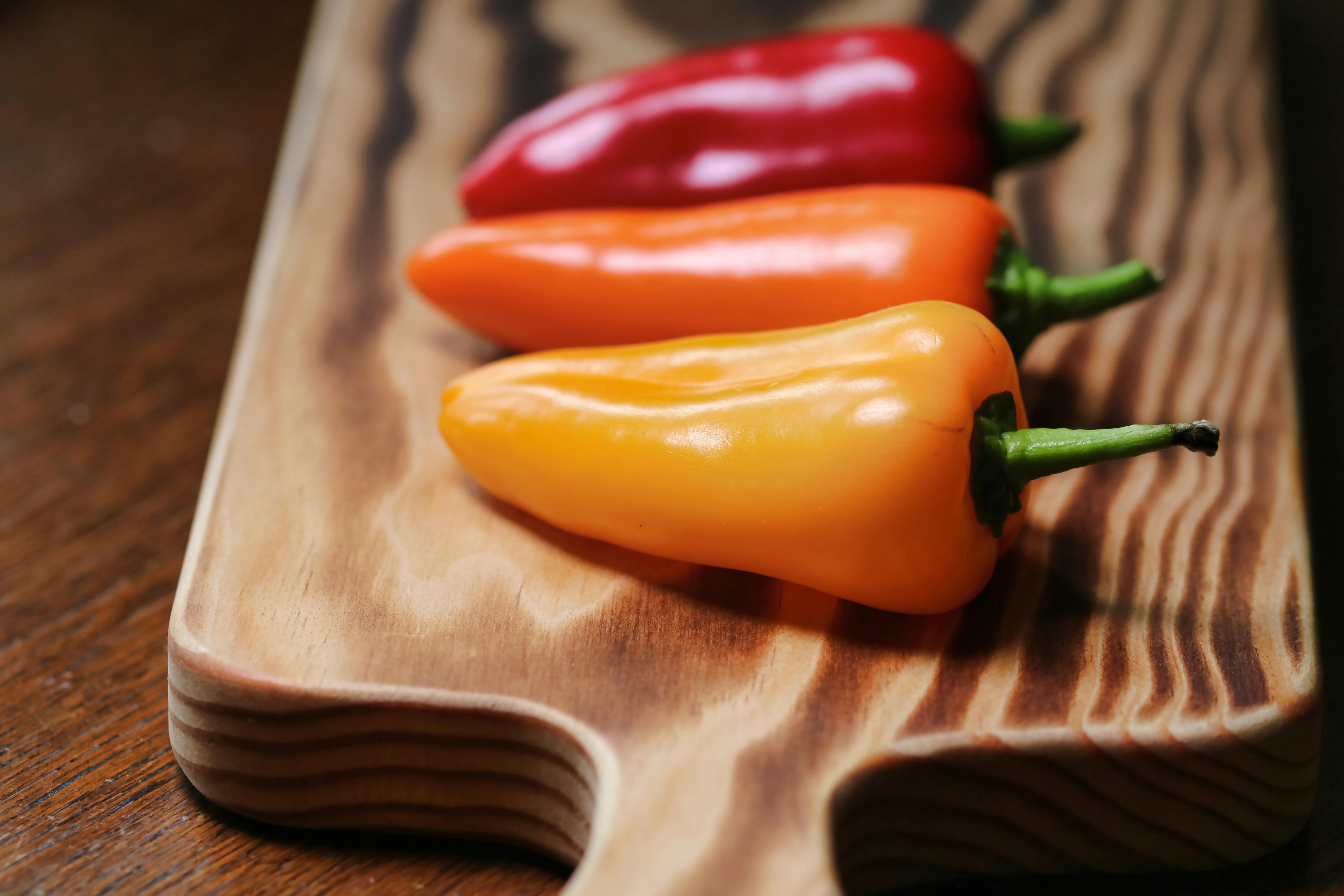 Three chili bell peppers on a cutting board used to make bayou Cajun chili.