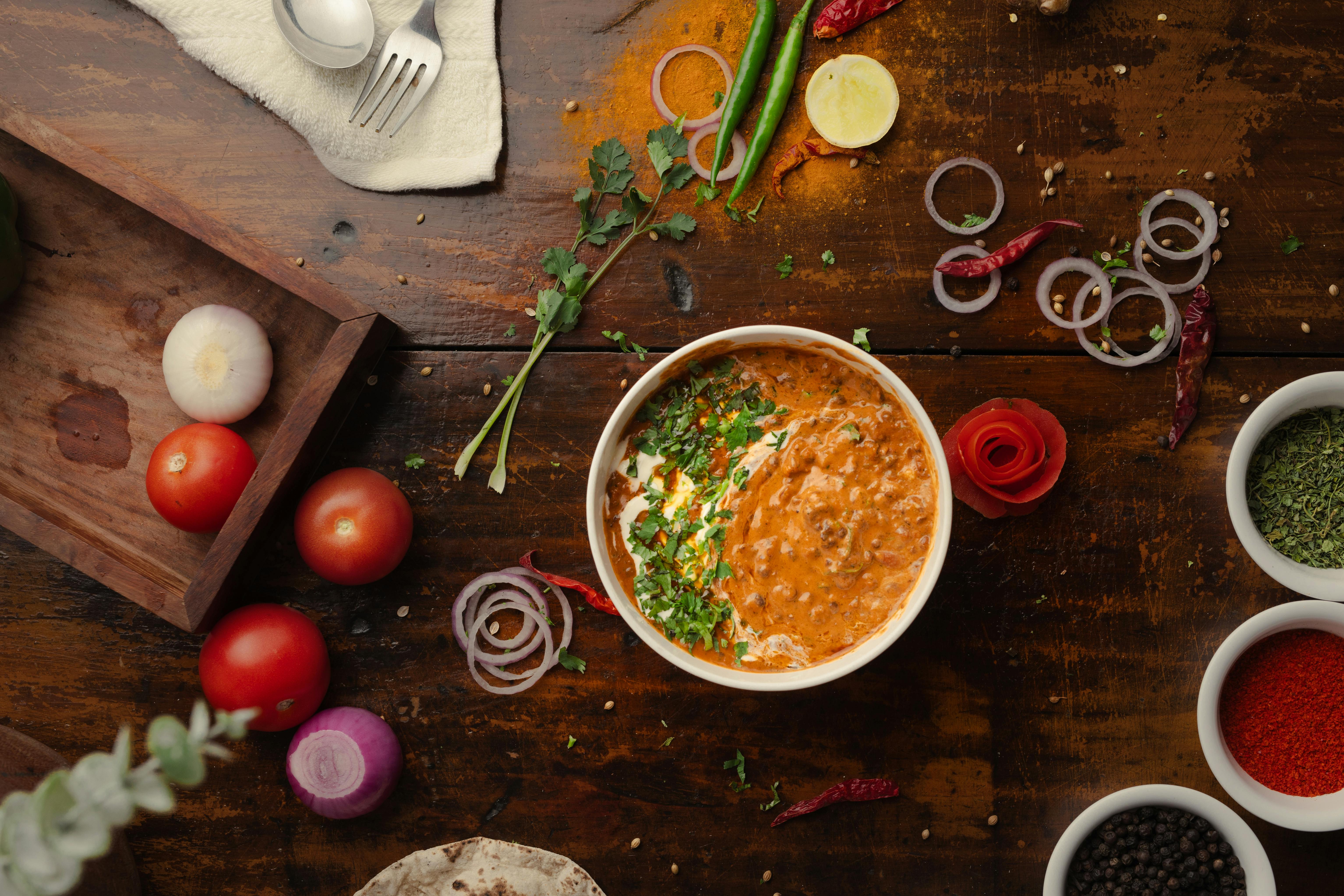 Bayou Cajun chili in a bowl surrounded by vegetables.