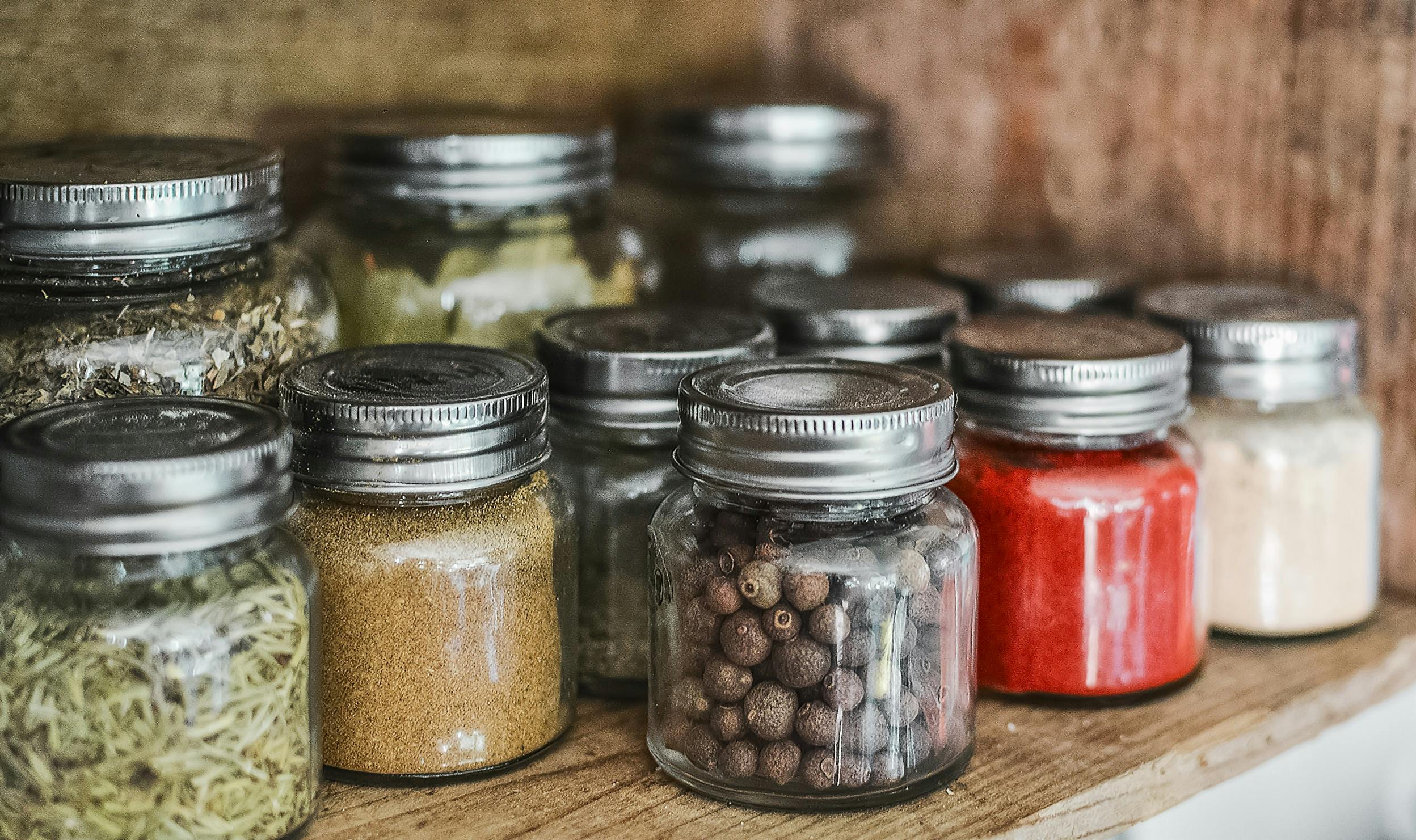 Various spices in different jars that are used to make bayou Cajun chili.